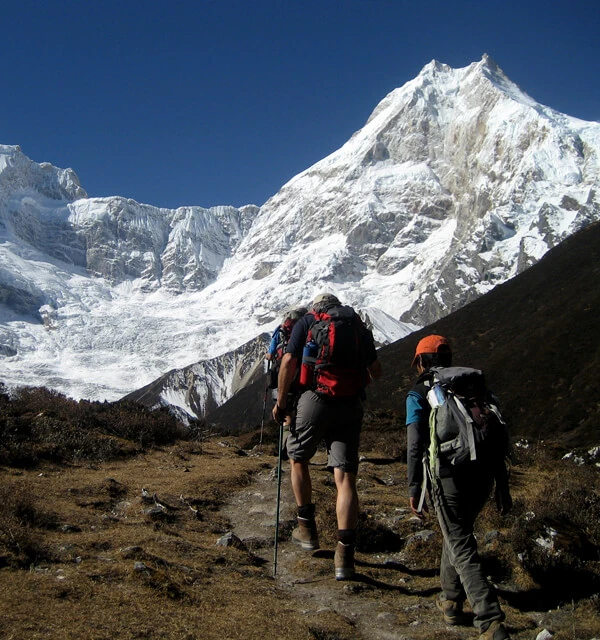 Trekkers walking through Himalayan valleys on the Manaslu Trek via Serang Gompa.