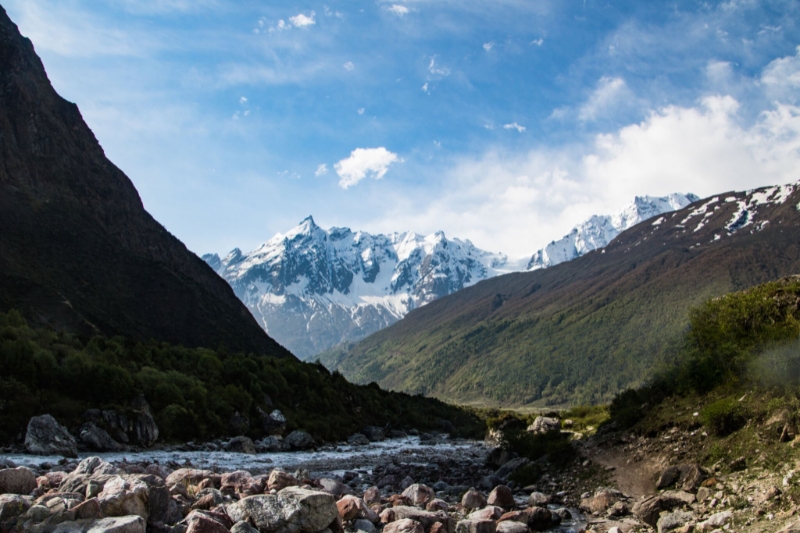 Trekkers walking along a rugged trail in Tsum Valley Trek with Himalayan mountains around.