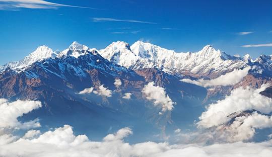 Snow capped Ganesh Himal seen from the Rupina La Pass trek with green hills and valleys in Nepal.