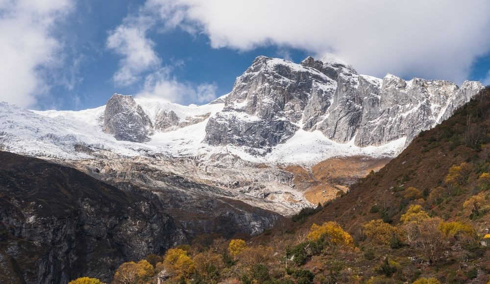 Adventurers trekking across snowy high passes on the Manaslu Three Passes Trek, with panoramic Manalsu peaks.
